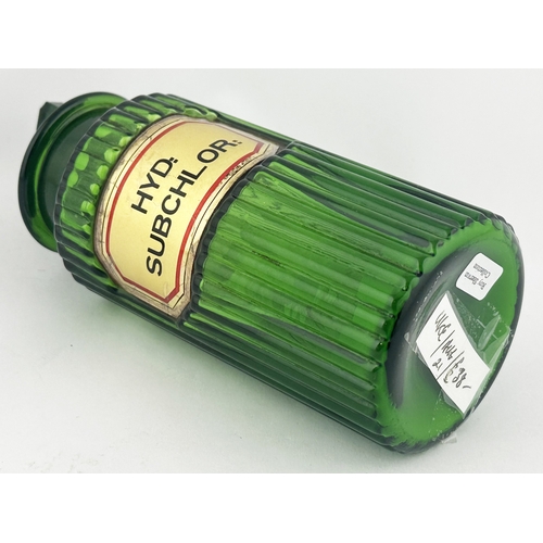 356 - RIBBED LABEL UNDER GLASS SHOP ROUND BOTTLE. 6.6.ins tall. Bright green wide mouth glass, inset affix... 