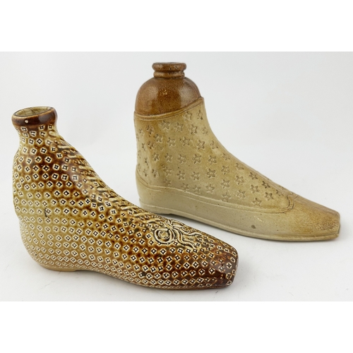 384 - SHOE SHAPED SPIRIT FLASK DUO. Largest 5.iins tall, 6.8ins long. Salt glazed pair of shoes, each with... 