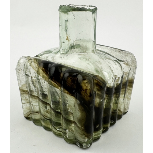 467 - SWIRLY FLUTED INK BOTTLE. 2.25ins tall. Sheared lip, three sides vertically ribbed, one plain flat s... 