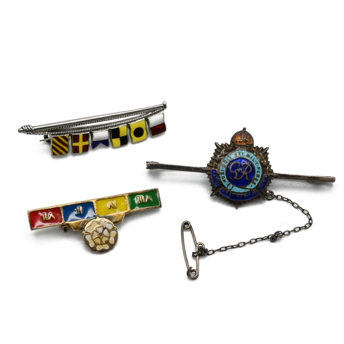 10 - A Naval signalling flags brooch, stamped ’Silver’; a silver and enamel sweetheart brooch; and a silv... 