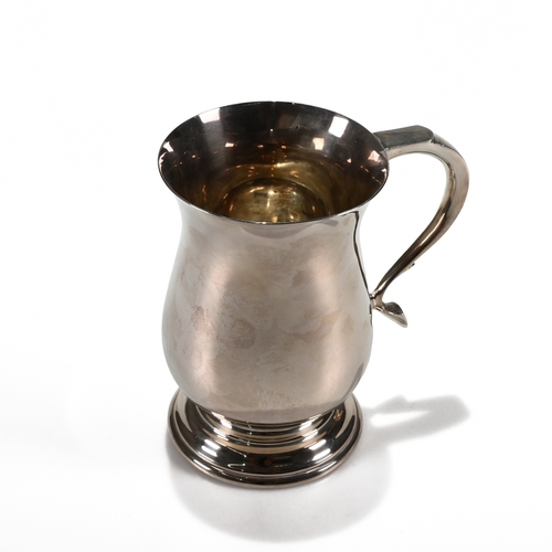 127 - A modern silver mug, maker DH, Sheffield 1969, of plain baluster form, scroll handle, 13.5cm high, 3... 