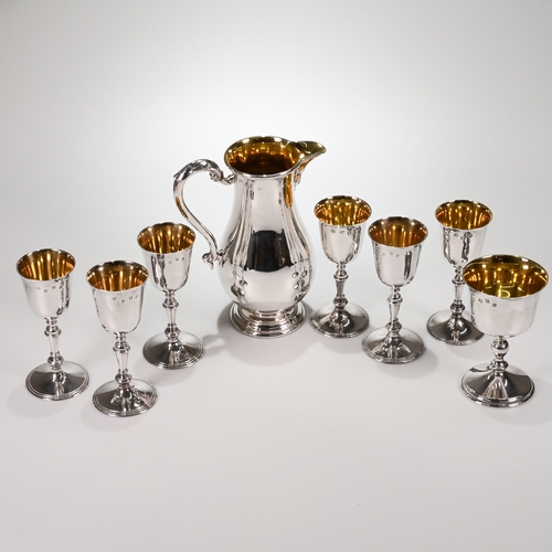 131 - A silver wine jug with a matched set of six silver wine goblets, and a larger goblet, Royal Irish Si... 