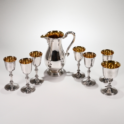 131 - A silver wine jug with a matched set of six silver wine goblets, and a larger goblet, Royal Irish Si... 