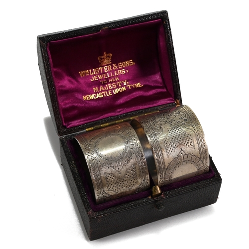 141 - A cased pair of Victorian silver napkin rings, Aldwinkle & Slater, London, 1885; with a cased silver... 