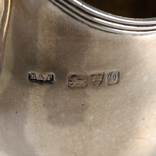 154 - A Georgian silver cream jug, makers mark worn, London 1805, of helmet shape, engraved with leafy who... 
