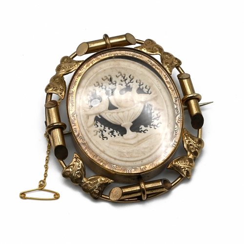 18 - A Victorian gilt metal revolving memorial brooch, with hair arrangement to one side and Pliny’s Dove... 