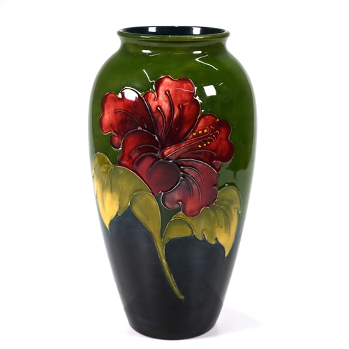 545 - A large (32cm) Moorcroft Hibiscus pattern vase with tube lined floral decoration on green ground bea... 