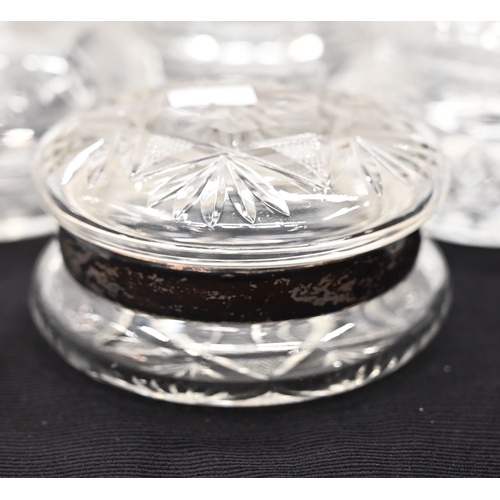 572 - A large quantity of cut glass dressing table jars with lids including one with hallmarked silver rim... 