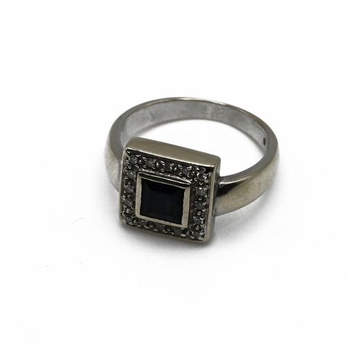 67 - A sapphire and diamond cluster ring, the white mount stamped ’18K750’, the square cut sapphire enclo... 