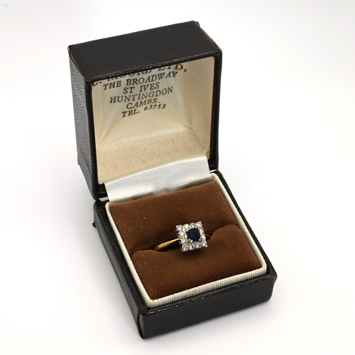 72 - A sapphire and diamond 18 carat gold cluster ring, the square cut sapphire enclosed bob twelve brill... 