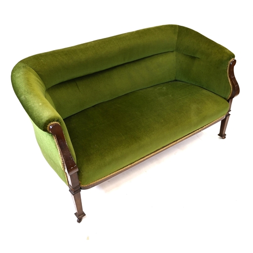 1013 - An early 20th Century green upholstered two seat sofa with sweeping Mahogany arms and feet. On caste... 