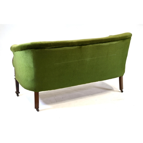 1013 - An early 20th Century green upholstered two seat sofa with sweeping Mahogany arms and feet. On caste... 