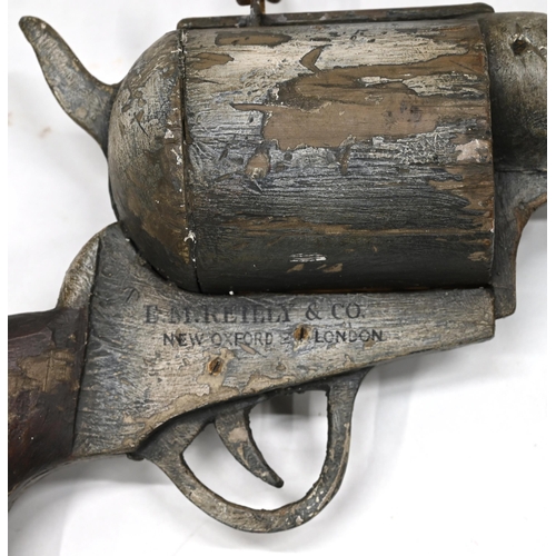 713 - A large carved and painted wooden advertising six shooter pistol bearing the name E.M.Reilly New Oxf... 