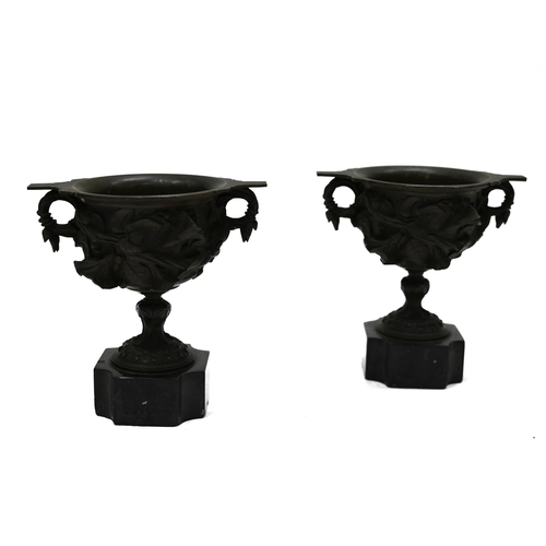 725 - A pair of 19th Century Grand Tour bronze two handled drinking cups mounted on square marble socles w... 