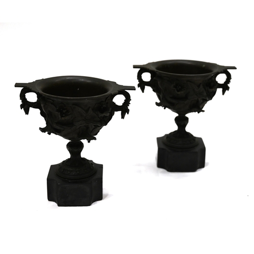 725 - A pair of 19th Century Grand Tour bronze two handled drinking cups mounted on square marble socles w... 