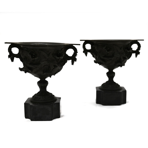 725 - A pair of 19th Century Grand Tour bronze two handled drinking cups mounted on square marble socles w... 