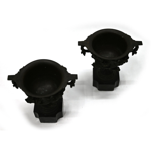 725 - A pair of 19th Century Grand Tour bronze two handled drinking cups mounted on square marble socles w... 