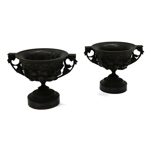 871 - A pair of 19th Century Grand Tour bronze two handled drinking cups mounted on round marble socles. E... 