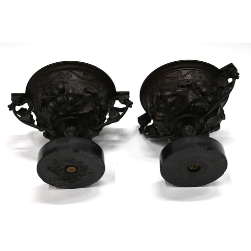 871 - A pair of 19th Century Grand Tour bronze two handled drinking cups mounted on round marble socles. E... 