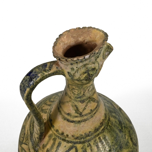 887 - A Seljuk Kashan cockerel headed pottery ewer, decorated in geometric green glazes over a yellow grou... 