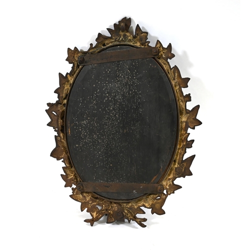 900 - An early 20th Century cast iron framed oval wall mirror. The frame profusely decorated in grapes and... 