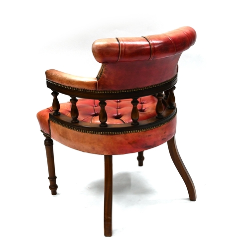 963 - A leather clad Captain's style chair, of mahogany frame with turned legs to the front an sabre to th... 