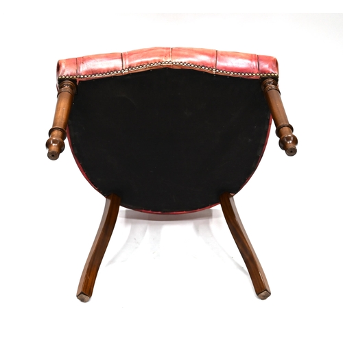 963 - A leather clad Captain's style chair, of mahogany frame with turned legs to the front an sabre to th... 