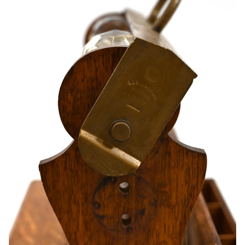 999 - An Edwardian oak tantalus with locking bar containing three square form decanters. The brass bound b... 