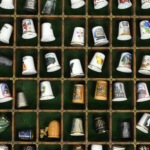 534 - A collection of 148 thimbles, including silver examples, displayed in a printer's typesetting drawer... 