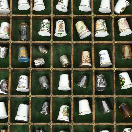 534 - A collection of 148 thimbles, including silver examples, displayed in a printer's typesetting drawer... 