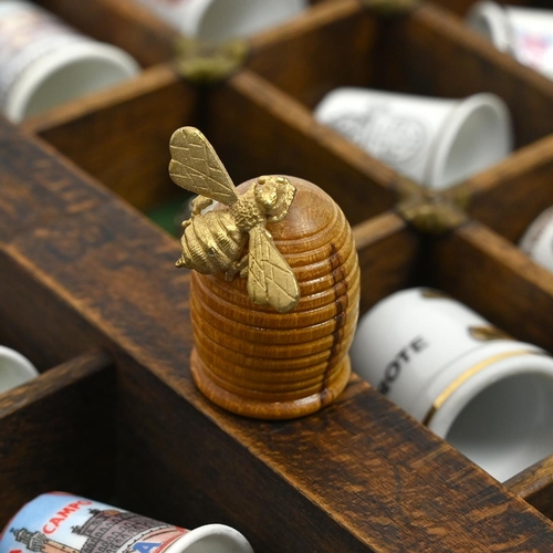 534 - A collection of 148 thimbles, including silver examples, displayed in a printer's typesetting drawer... 