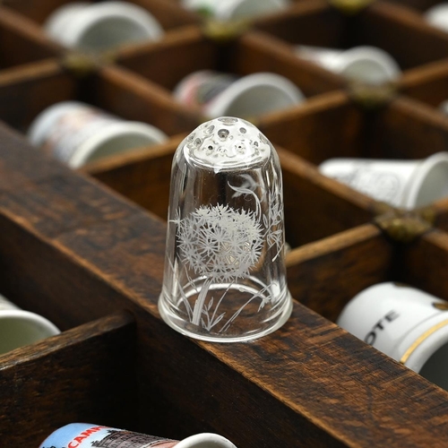 534 - A collection of 148 thimbles, including silver examples, displayed in a printer's typesetting drawer... 