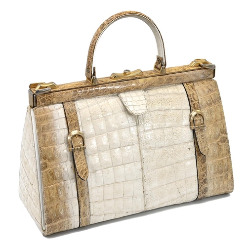 562 - A vintage cream and brown crocodile skin handbag, with a brass push lock and straps and having suede... 