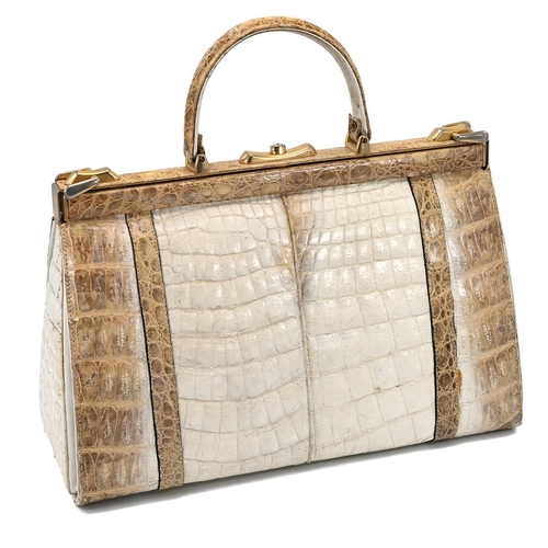 562 - A vintage cream and brown crocodile skin handbag, with a brass push lock and straps and having suede... 