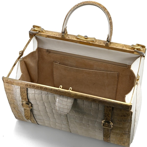 562 - A vintage cream and brown crocodile skin handbag, with a brass push lock and straps and having suede... 