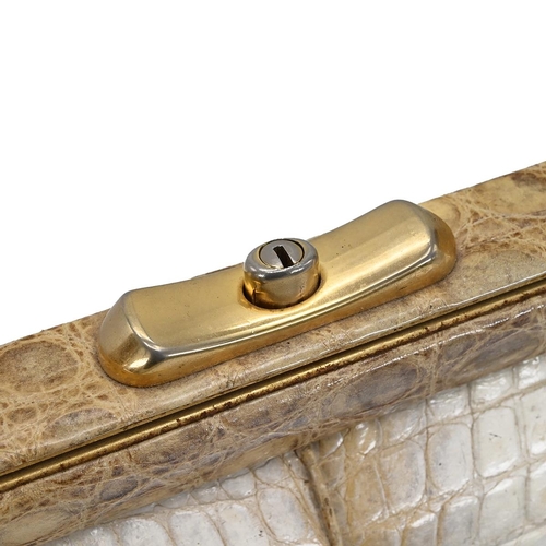 562 - A vintage cream and brown crocodile skin handbag, with a brass push lock and straps and having suede... 