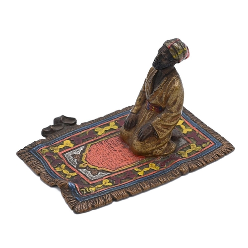 568 - Bergman style cold painted bronze figure of a male figure performing Salah on a prayer mat. H 5cm, W... 