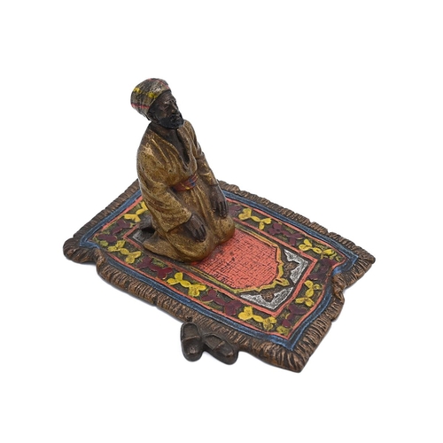 568 - Bergman style cold painted bronze figure of a male figure performing Salah on a prayer mat. H 5cm, W... 