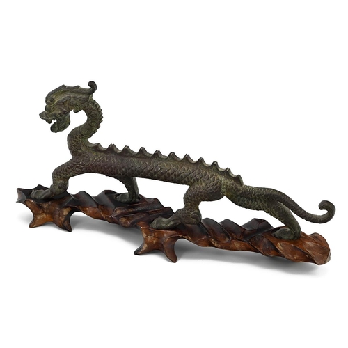 575 - A Chinese bronze model of a dragon, on a fitted hardwood stand, 30cm long, 14cm high 