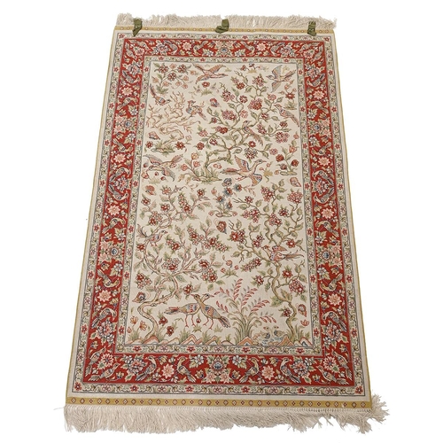 578 - Indian hand woven Isfahan silk warp rug, cream ground with birds in fruit trees surround by a dark r... 