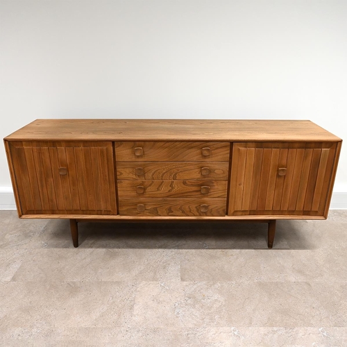 591 - An Ensign Elm sideboard by Bristow and Townsend comprising four long drawers flanked by cupboards wi... 