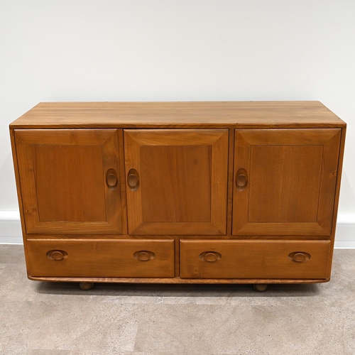 592 - Ercol Windsor light elm sideboard, fitted with three cupboards over two drawers all with carved oval... 