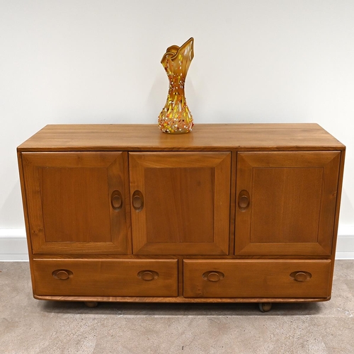 592 - Ercol Windsor light elm sideboard, fitted with three cupboards over two drawers all with carved oval... 