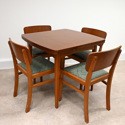 602 - Mid Century Teak dining table and four chairs. The draw-leaf extending table of rounded square form ... 