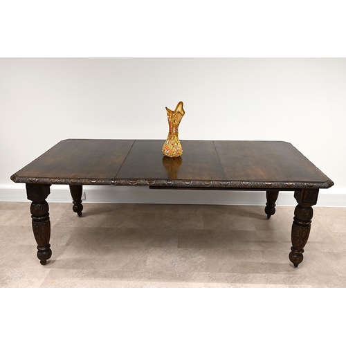 603 - Late Victorian carved oak extending dining table and eight chairs. The table with carved edge and he... 