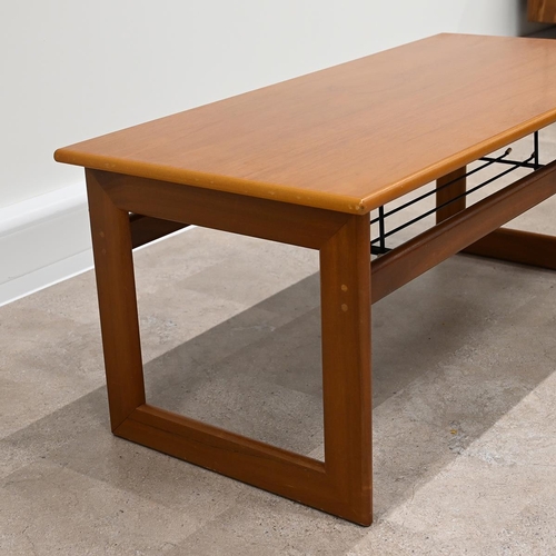 606 - Mid Century teak coffee table of rectangular form with wire magazine tray under raised on square fra... 