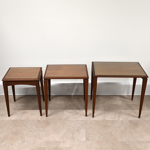 607 - Mid century teak nest of three tables of rectangular form, each with inset glass protectors, raised ... 