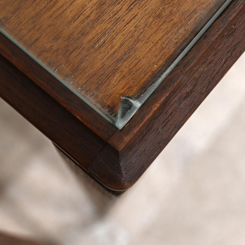 607 - Mid century teak nest of three tables of rectangular form, each with inset glass protectors, raised ... 