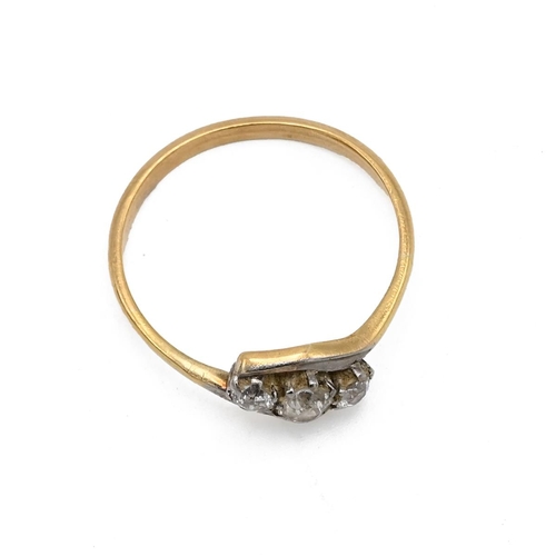 32 - An 18ct gold and three stone diamond crossover ring, the brilliant cut stones weighing approximately... 