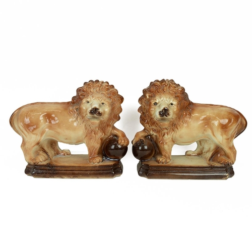 94 - Pair of Staffordshire Lions with paws raised on globes. Height 18cm, Width 33cm. (2) (M)